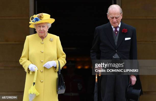 Britain's Queen Elizabeth II and Britain's Prince Philip, Duke of Edinburgh observe a minute's silence at the start of a Special Garden Party at...