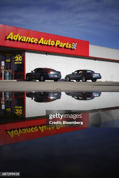 Vehicles are reflected in a puddle outside an Advanced Auto Parts Inc. Store in Shepherdsville, Kentucky, U.S., on Monday, May 22, 2017. Advanced...