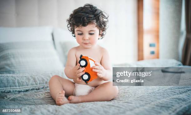 menino jogando na cama. - bebês meninos - fotografias e filmes do acervo