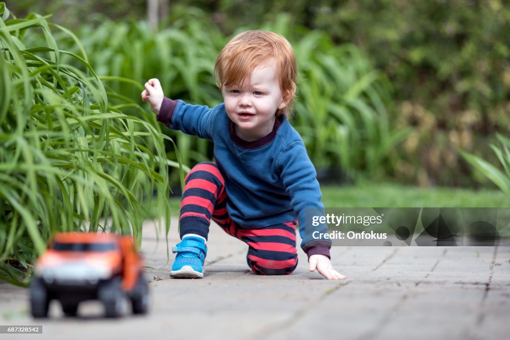 Baby Boy Playing With Toy Vehicle Outdoor