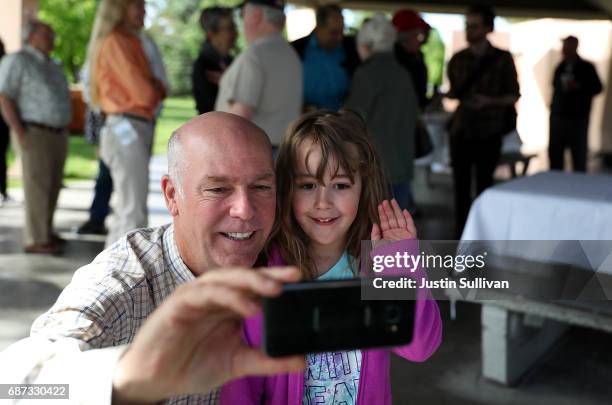 Republican congressional candidate Greg Gianforte takes a selfie with a young girl during a campaign meet and greet at Lions Park on May 23, 2017 in...