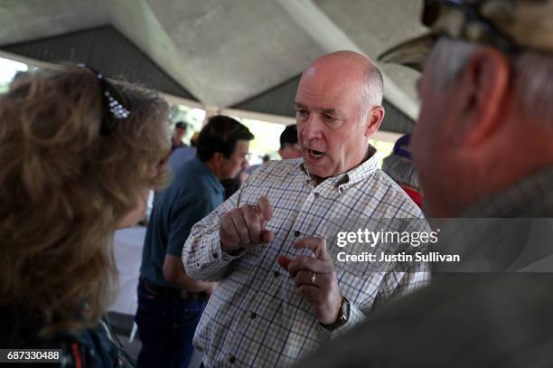 Republican congressional candidate Greg Gianforte talks with supporters during a campaign meet and greet at Lions Park on May 23, 2017 in Great...