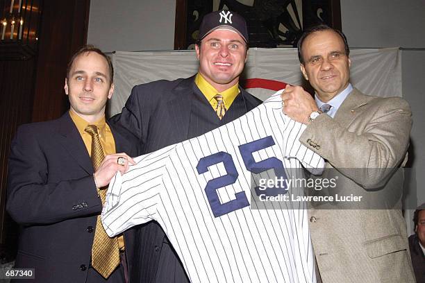 Baseball player Jason Giambi poses with Yankees General Manager Brian Cashman and Manager Joe Torre at Yankee Stadium to announce Giambis signing...