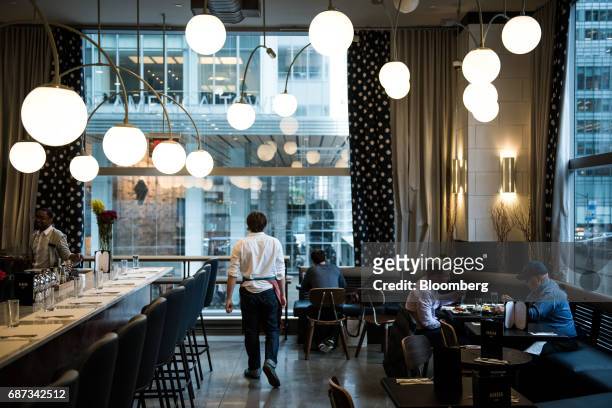 Waiter walks through the Harbor Bar restaurant at a Whole Foods Market Inc. Location in New York, U.S., on Tuesday, May 22, 2017. Whole Foods Market...