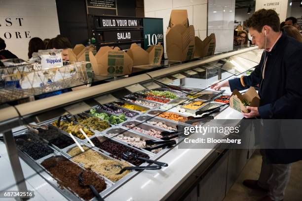 Man serves himself from the "Build Your Own Salad" bar at a Whole Foods Market Inc. Location in New York, U.S., on Tuesday, May 22, 2017. Whole Foods...