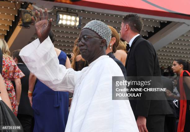 Malian director Souleymane Cisse waves as he arrives on May 23, 2017 for the '70th Anniversary' ceremony of the Cannes Film Festival in Cannes,...