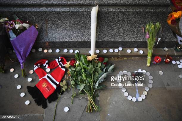 Manchester United scarf, laid in the shape of a heart, lies next to flowers left by members of the public at a candlelit vigil, to honour the victims...