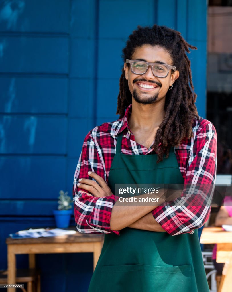 Camarero feliz trabajando en un café al aire libre