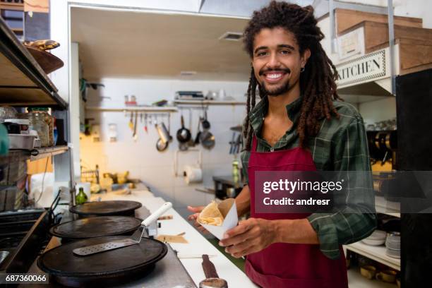 happy man serving crepes at a restaurant - making pancakes stock pictures, royalty-free photos & images