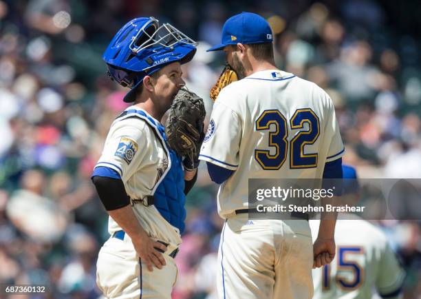 Catcher Tuffy Gosewisch of the Seattle Mariners and starting pitcher Chris Heston of the Seattle Mariners meet at the pitcher's mond during a game...