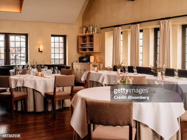 Tables sit inside the dining room of the Blue Hill at Stone Barns restaurant in Pocantico Hills, New York, U.S., on Friday, April 21, 2017. As...