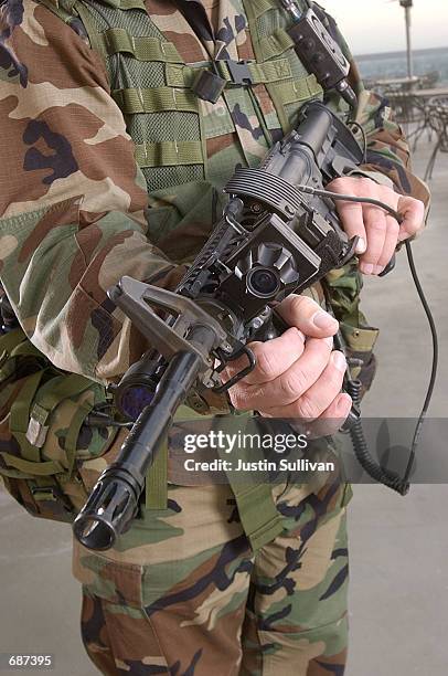 Army Sgt. Chris Augustine displays a M4 Carbine assault rifle as he models the 0.6 Land Warrior System December 13, 2001 at the Homeland Security...