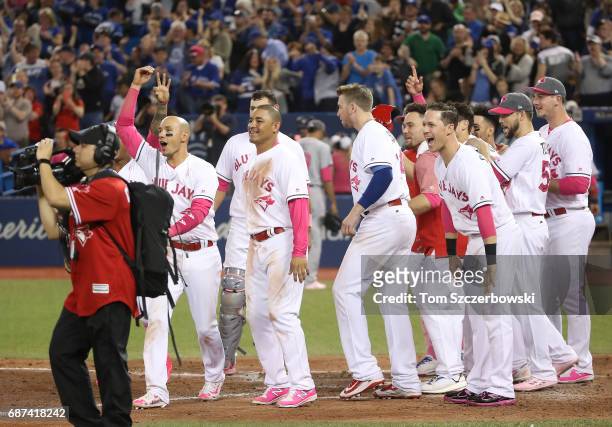 Ryan Goins of the Toronto Blue Jays and Ezequiel Carrera and Chris Coghlan and teammates wait to greet Kevin Pillar after his game-winning solo home...