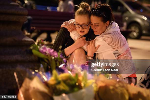 Woman is consoled as she looks at the floral tributes following an evening vigil outside the Town Hall on May 23, 2017 in Manchester, England. An...