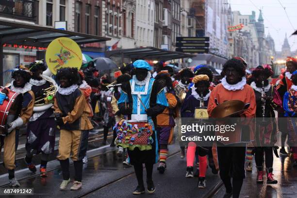 People attends the arrival of Sinterklaas, the Dutch version of Santa Claus and his 'Zwarte Piet', or Black Pete with blackface in Amsterdam,...