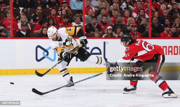 Bryan Rust of the Pittsburgh Penguins fires a shot with pressure from Erik Karlsson of the Ottawa Senators in Game Six of the Eastern Conference...