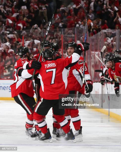 Mike Hoffman of the Ottawa Senators celebrates with teammates Fredrik Claesson and Kyle Turris after scoring a third period goal on the Pittsburgh...