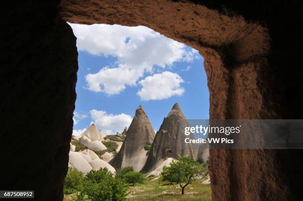 Fairy chimneys' rock formations seen through the entrance of a cave dwelling between Ortahisar and G_reme in Cappadocia.
