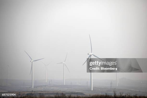 Wind turbines operate in the distance from a showcase farm operated by Penglai Hesheng Agricultural Technology Development Co. In Penglai, Shandong...