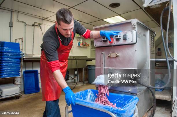 Man using meat grinder for baloney making in Frostburg, MD.