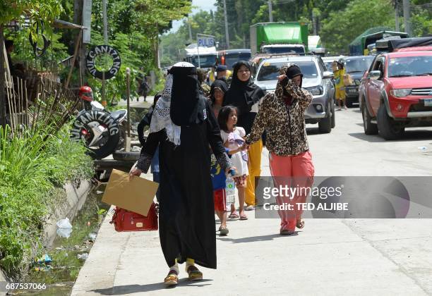 Residents fleeing from Marawi, where gunmen who had declared allegiance to the Islamic State group rampaged through the southern city, walk past a...