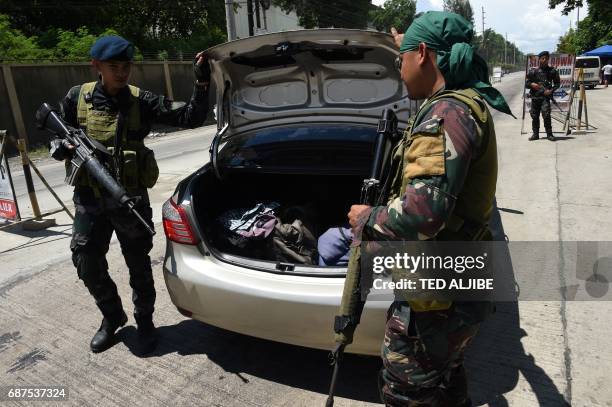 Philippine policemen check a car boot of a resident fleeing from Marawi city, where gunmen who had declared allegiance to the Islamic State group...