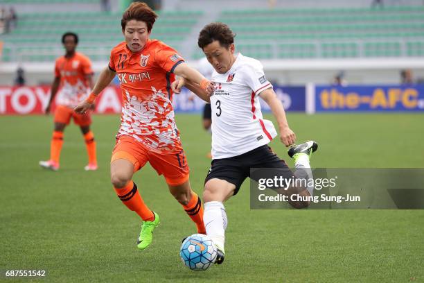 Tomoya Ugajin of Urawa Red Diamonds competes for the ball with Ahn Hyun-Beom of Jeju United FC during the AFC Champions League Round of 16 match...