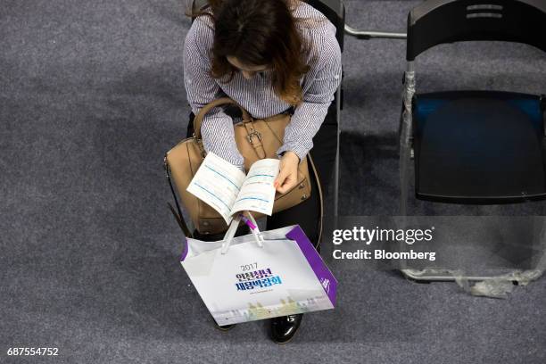 Jobseeker reads an information booklet at a job fair in Incheon, South Korea, on Wednesday, May 24, 2017. South Korea is scheduled to release...