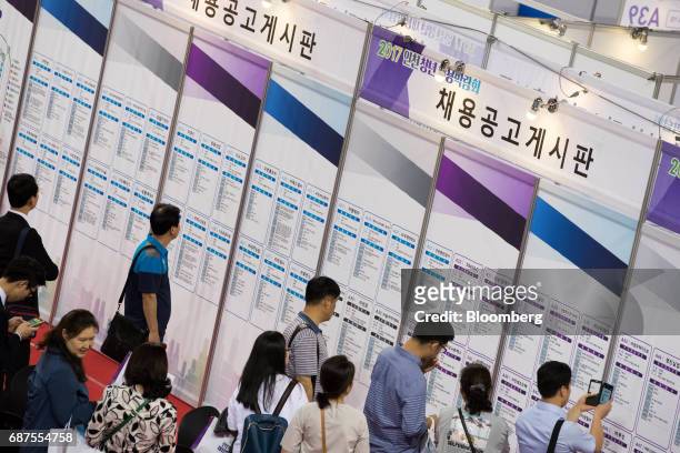 Jobseekers look at listings displayed at a job fair in Incheon, South Korea, on Wednesday, May 24, 2017. South Korea is scheduled to release...