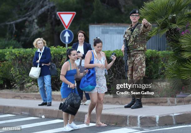 Italian soldier directs women at a checkpoint at a road leading up to the historic town of Taormina, which will host the upcoming G7 summit, on the...