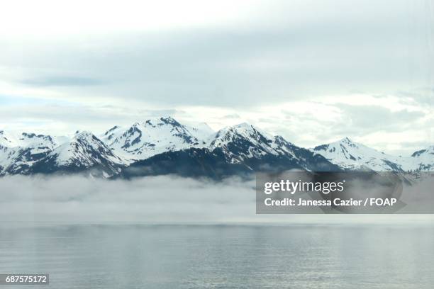 snowy mountains in foggy weather - janessa stockfoto's en -beelden