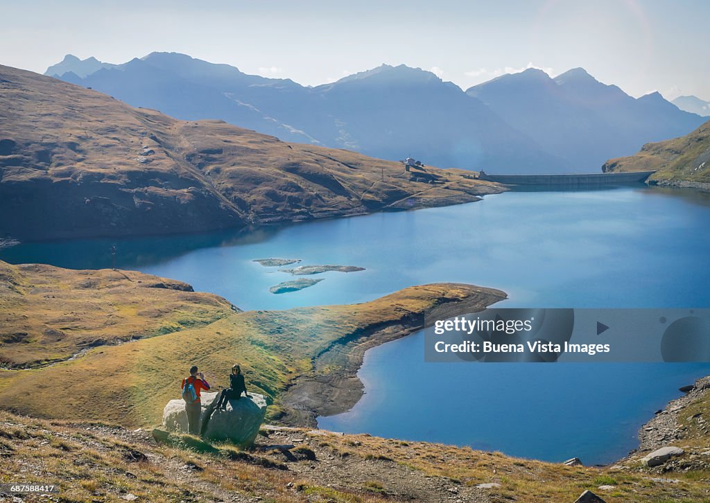 Couple taking pictures near an alpine lake