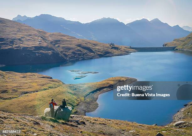 couple taking pictures near an alpine lake - piemonte - fotografias e filmes do acervo