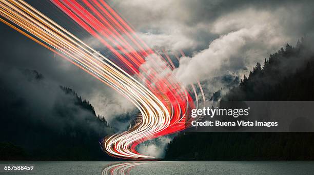 light beams over a mountain lake - light trail stock-fotos und bilder