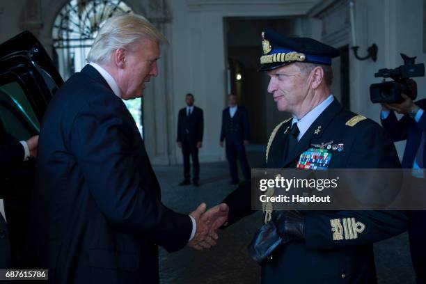 In this handout image provided by Ufficio Stampa e Comunicazione della Presidenza della Repubblica, US President Donald Trump shake hands with...