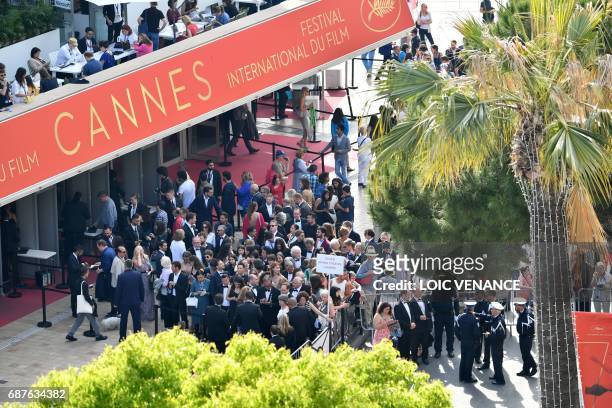 Journalists line up on May 23, 2017 to attend the '70th Anniversary' ceremony of the Cannes Film Festival in Cannes, southern France. / AFP PHOTO /...