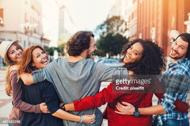 group of friends holding together and looking back - arm in arm stock pictures, royalty-free photos & images