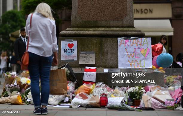 Woman looks at flowers in Albert Square in Manchester, northwest England on May 24 placed in tribute to the victims of the May 22 terror attack at...