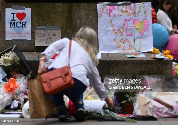 Woman places flowers beneath a sign that reads "Ariana we love you" in St Ann's Square in Manchester, northwest England on May 24 in tribute to the...