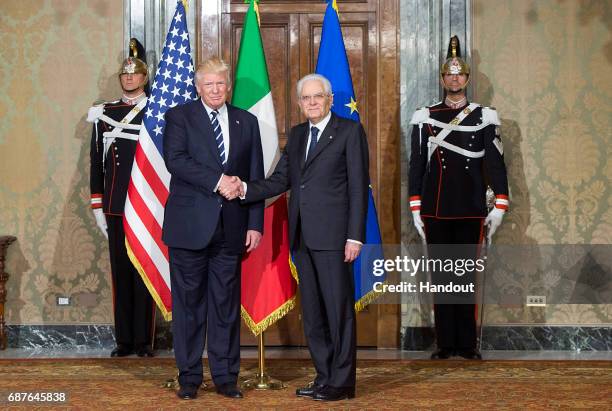 In this handout image provided by Ufficio Stampa e Comunicazione della Presidenza della Repubblica, US President Donald Trump shake hands with...