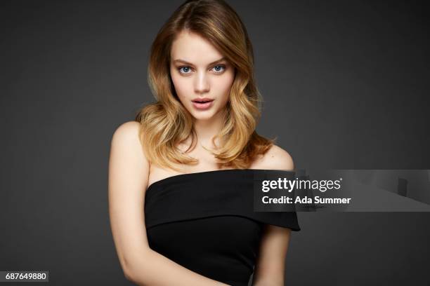 beautiful blonde woman in black one shoulder cocktail dress - long hair model stock-fotos und bilder