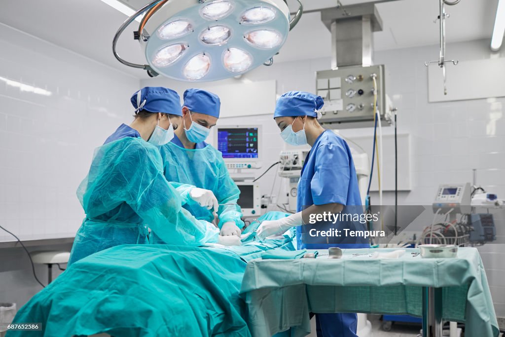 Squadra di chirurghi in sala operatoria in ospedale.