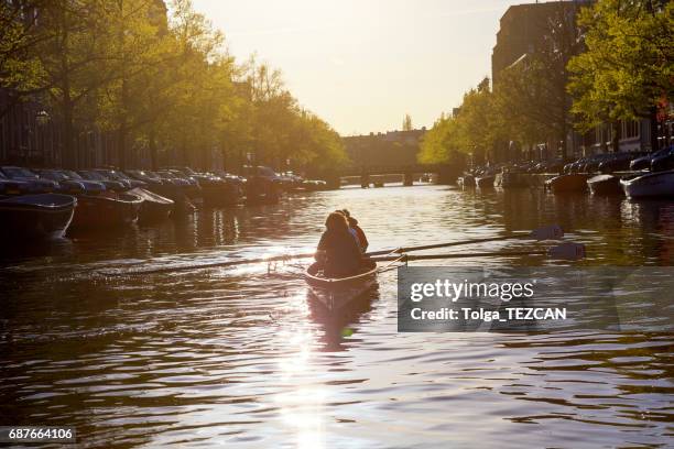 ruderboot auf wasser-kanäle von amsterdam, niederlande - fluss amstel stock-fotos und bilder