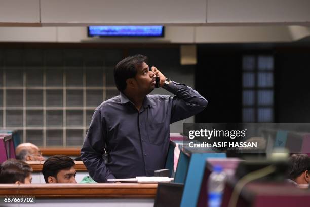 Pakistani stockbroker watches share prices on monitor during a trading session at the Pakistan Stock Exchange in Karachi on May 24, 2017. The...