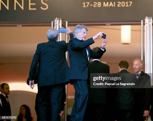 French director Claude Lelouch and French-Polish director Roman Polanski film with their mobile phones as they arrive at the 70th Anniversary...