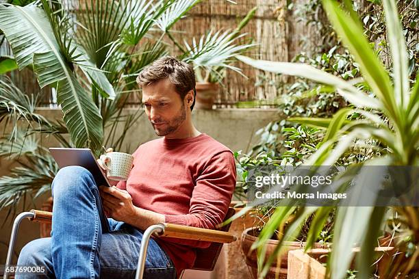 man using digital tablet while having coffee - coffee outside bildbanksfoton och bilder