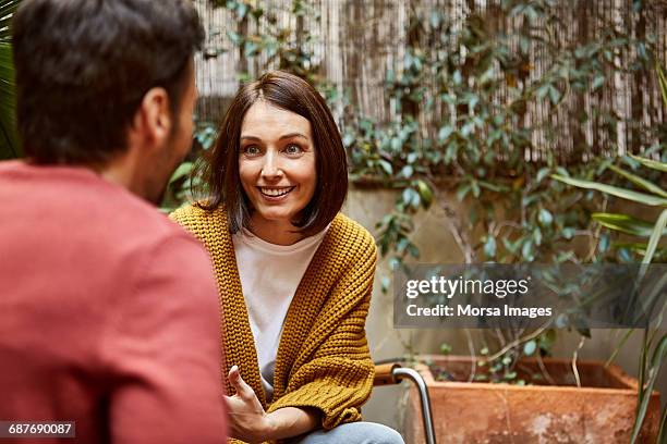 smiling woman looking at man in yard - couple talking stock pictures, royalty-free photos & images