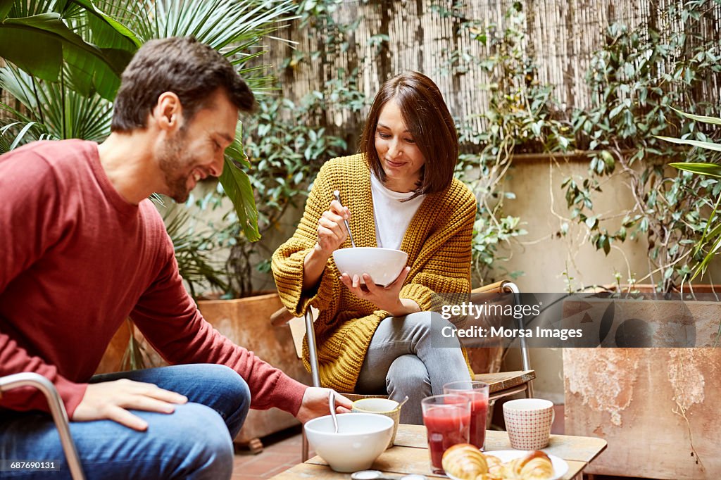 Mid adult couple having breakfast in yard