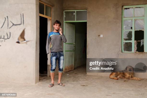 Azad, one of the two siblings who was accused of theft and whose right hand was cut off by Daesh, plays with a dog in Ninova, Iraq on May 23, 2017....