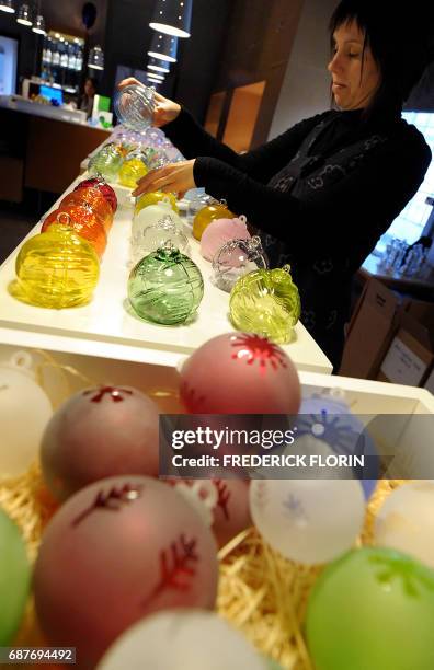 Une personne range des boules de Noël en verre le 01 décembre 2009 dans l'atelier de la verrerie de Meisenthal. Avec ses boules de Noël en forme...
